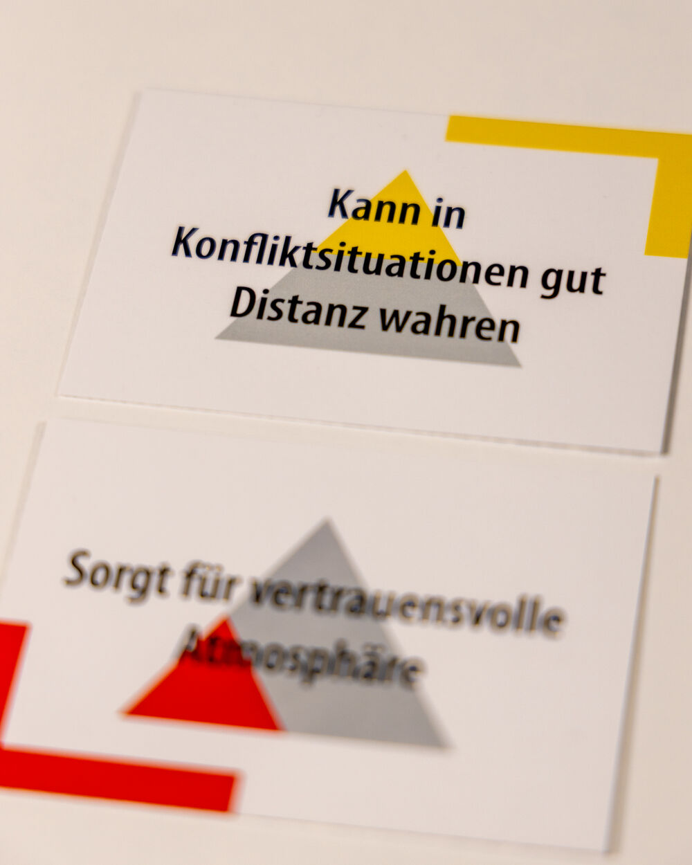 Moderationskarten mit den Aufschriften „Kann in Konfliktsituationen gut Distanz wahren“ und „Sorgt für vertrauensvolle Atmosphäre“